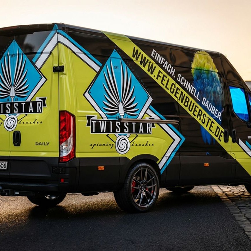 TWISSTAR — folierter Iveco-Transporter in Lime, Cyan und Schwarz im Stadtbild