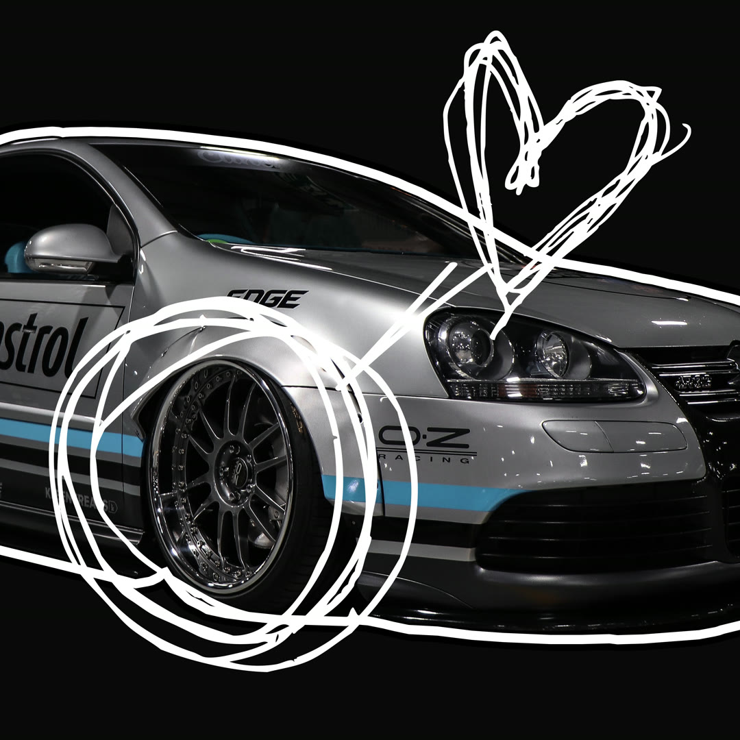A silver tuned VW Golf on black with cyan livery and forged wheels, a hand-drawn heart scribbled around it.