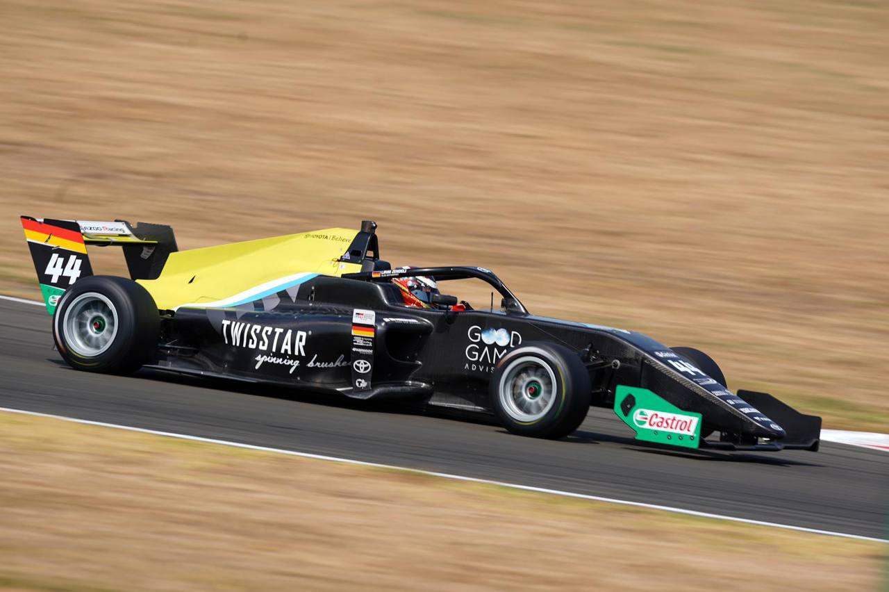 The TwistStar-liveried Formula 3 car at speed on track — lime and cyan bodywork.