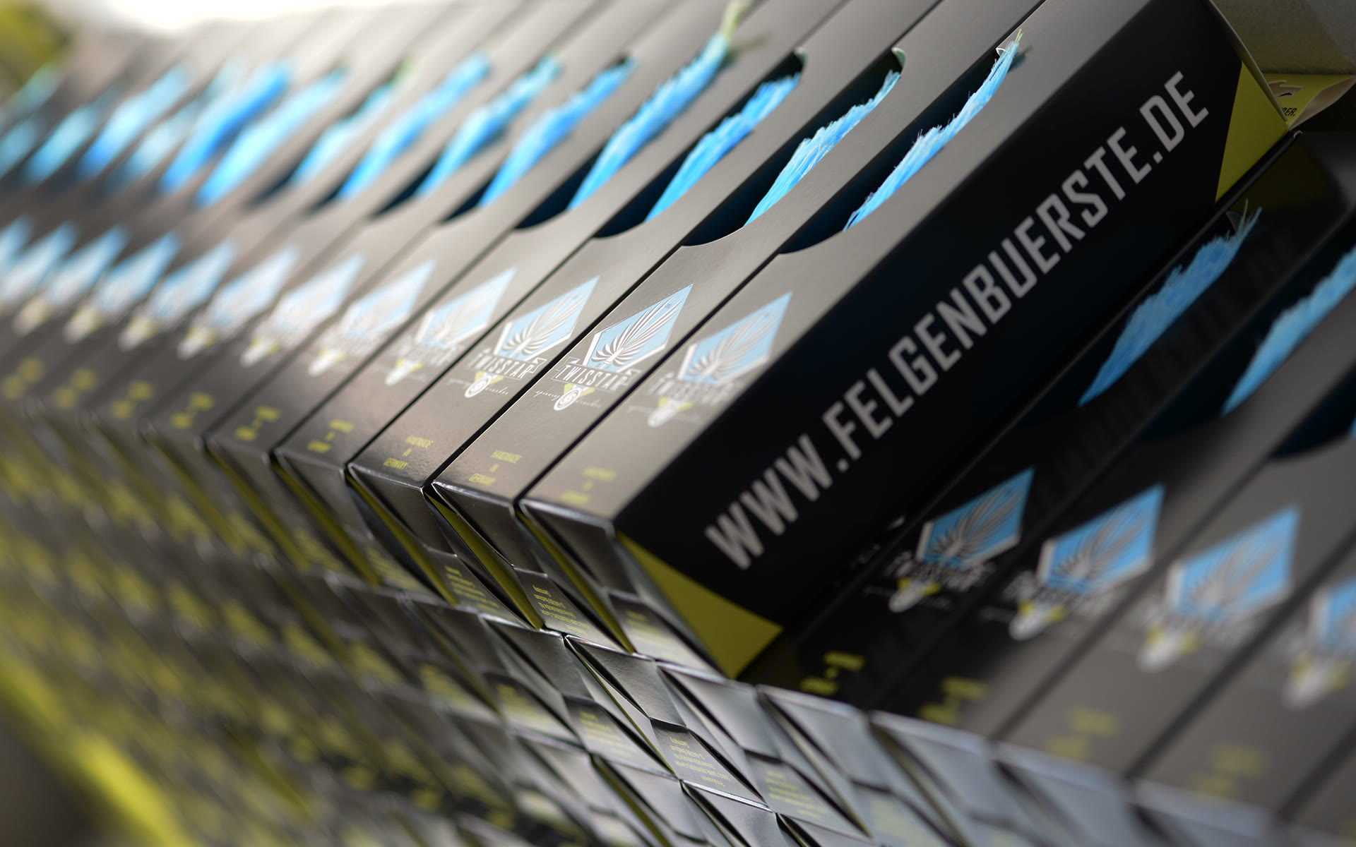 Hundreds of TwistStar retail boxes stacked edge to edge, 'www.felgenbuerste.de' running across the spines.